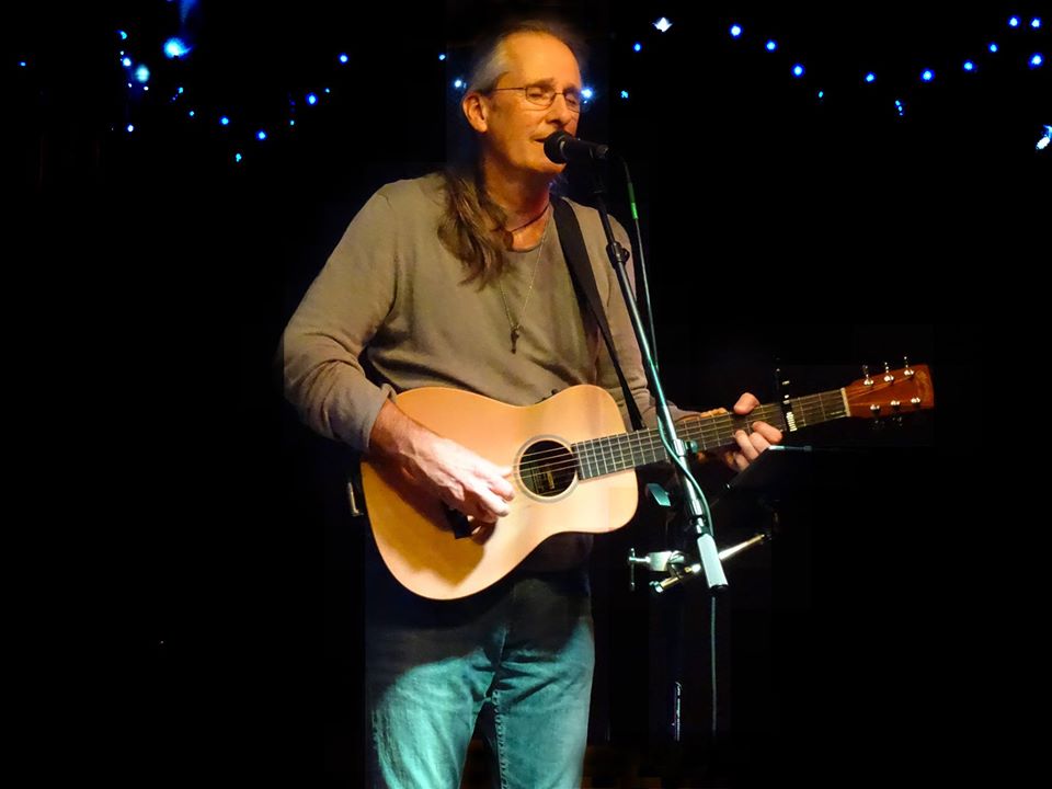 A person playing guitar and singing into a microphone

AI-generated content may be incorrect.